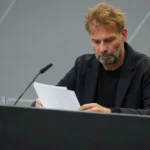 Jürgen Klopp bekijkt notities in een persruimte van de Duitse voetbalbond.
