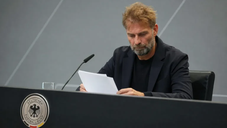 Jürgen Klopp bekijkt notities in een persruimte van de Duitse voetbalbond.