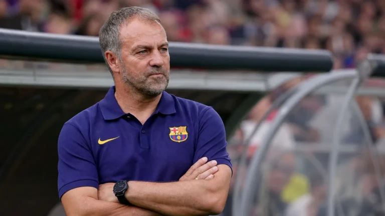 Een trainer in een donkerblauwe FC Barcelona-polo langs de zijlijn.
