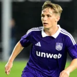 Danylo Sikan in het paarse shirt van RSC Anderlecht op een verlicht voetbalveld.