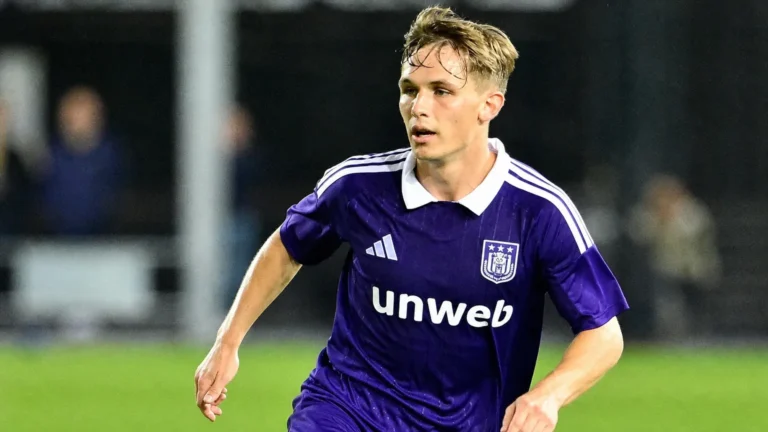 Danylo Sikan in het paarse shirt van RSC Anderlecht op een verlicht voetbalveld.