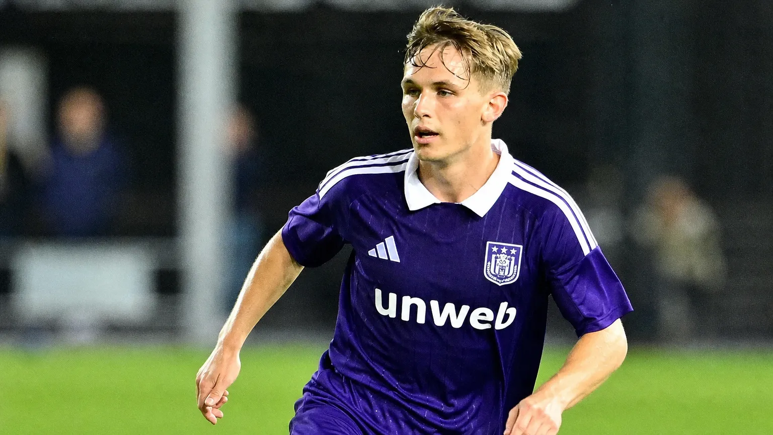 Danylo Sikan in het paarse shirt van RSC Anderlecht op een verlicht voetbalveld.