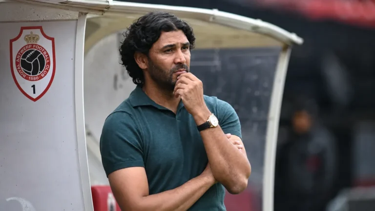 Een coach in donker poloshirt naast de dug-out van Antwerp aan de Bosuil.