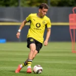Konstantinos Karetsas in geel Borussia Dortmund-tenue tijdens een baloefening op training.