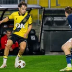 Jannes Van Hecke in een geel-zwart voetbalshirt tijdens een duel om de bal.