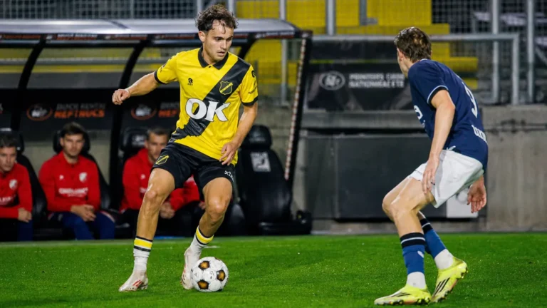 Jannes Van Hecke in een geel-zwart voetbalshirt tijdens een duel om de bal.