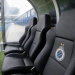Lege dug-out van Club Brugge met een clubembleem op een zitje.