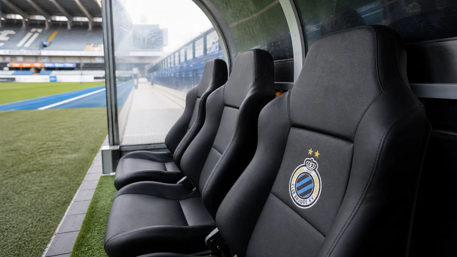 Lege dug-out van Club Brugge met een clubembleem op een zitje.