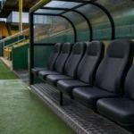 Een lege dug-out van Norwich City met een clubembleem op de vaste zitbank.