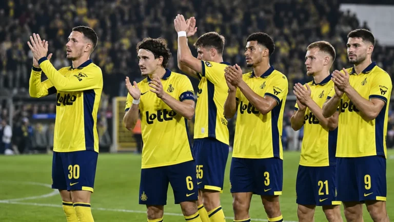 Een groep spelers van Union SG applaudisseert samen op het veld.
