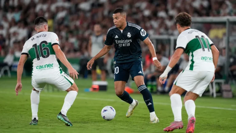 Kylian Mbappé in duel met spelers van Elche tijdens een wedstrijdmoment.