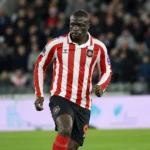 Een Sunderland-speler in rood-wit gestreept tenue tijdens een Europees duel.
