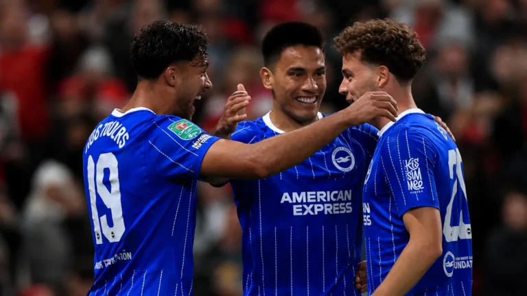 Drie spelers van Brighton vieren samen tijdens een wedstrijd op Old Trafford.