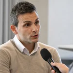Philippe Bormans spreekt rustig met journalisten tijdens een interview.