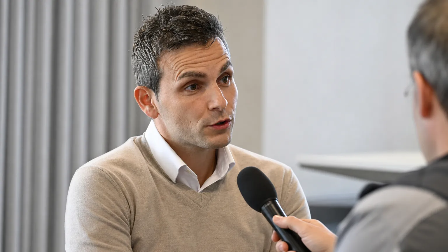Philippe Bormans spreekt rustig met journalisten tijdens een interview.