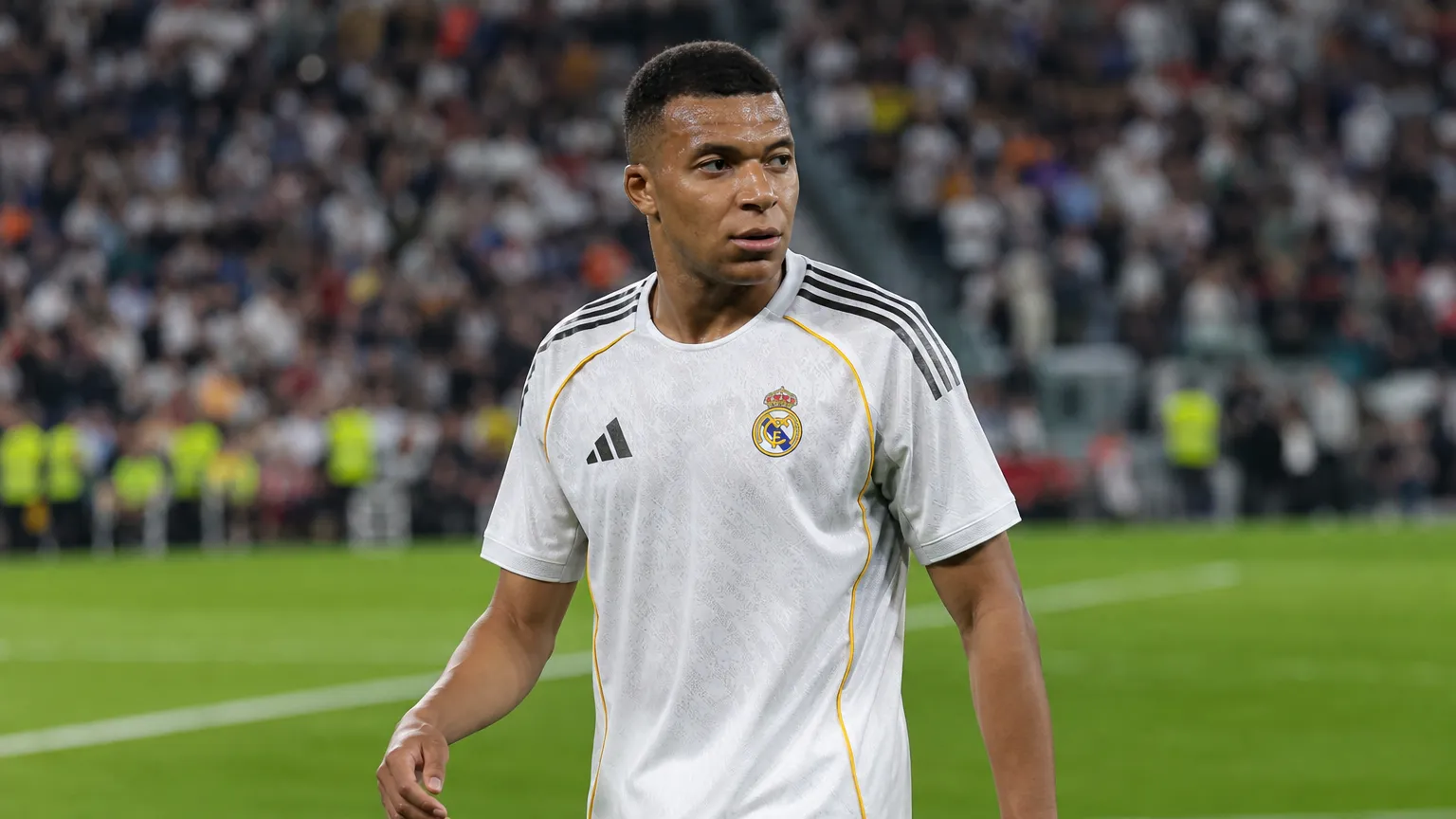Kylian Mbappé in het tenue van Real Madrid tijdens een geconcentreerd moment op het veld.