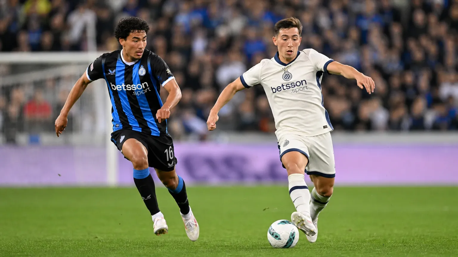 Twee voetballers in hun brontenues tijdens een nieuw wedstrijdmoment.