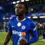 Romeo Lavia in een blauw Chelsea-shirt tijdens een rustig moment op het veld.