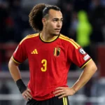 Arthur Theate in het Belgische nationale shirt aan de rand van een voetbalveld.