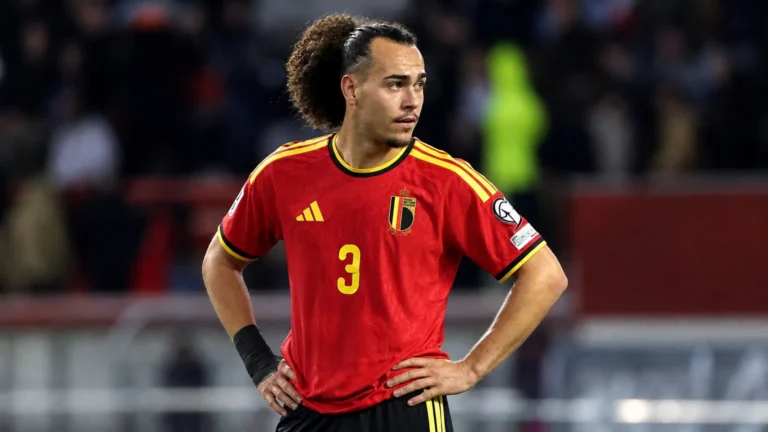 Arthur Theate in het Belgische nationale shirt aan de rand van een voetbalveld.