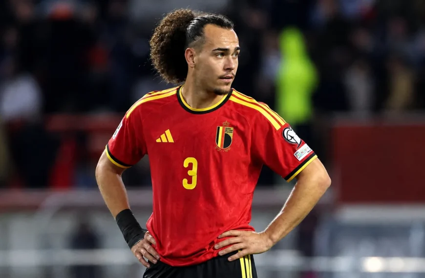 Arthur Theate in het Belgische nationale shirt aan de rand van een voetbalveld.