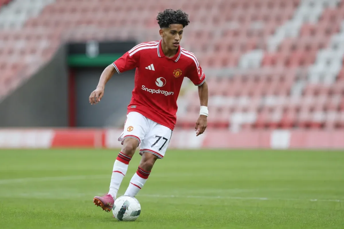 JJ Gabriel in een rood shirt en witte short tijdens een voetbalactie.