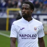 Majeed Ashimeru in het shirt van RSC Anderlecht aan de zijlijn van een stadion.