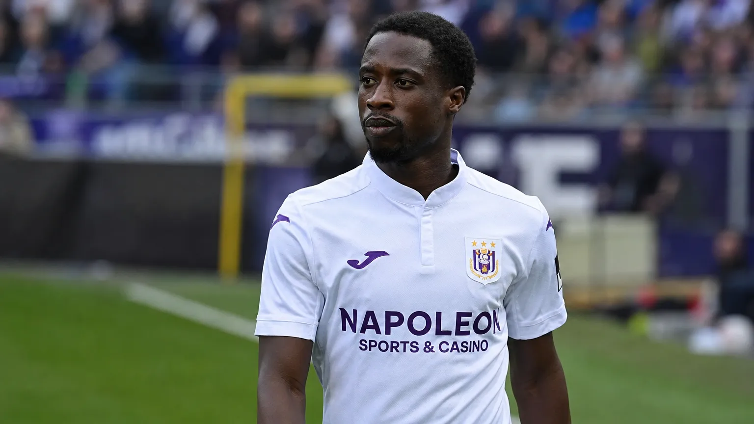 Majeed Ashimeru in het shirt van RSC Anderlecht aan de zijlijn van een stadion.