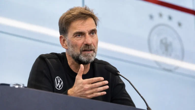 Jürgen Klopp spreekt achter een microfoon tijdens een persconferentie.