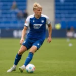 Nathan De Cat tijdens de warming-up in het tenue van Hoffenheim op het grasveld.
