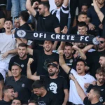 Supporters van OFI Kreta vieren in de tribunes een Europese thuiszege.