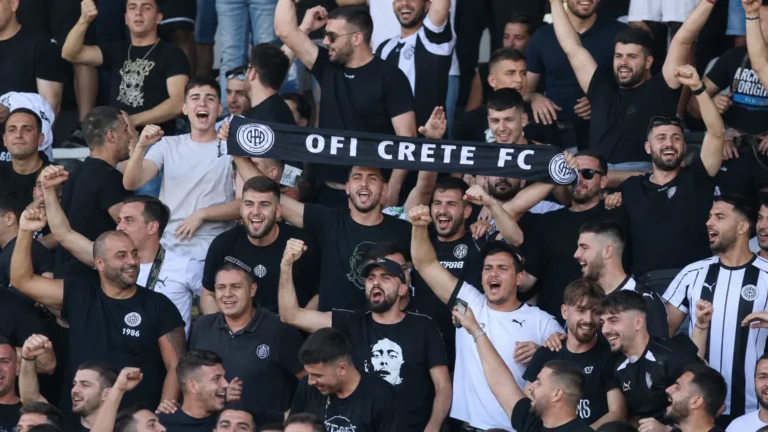 Supporters van OFI Kreta vieren in de tribunes een Europese thuiszege.