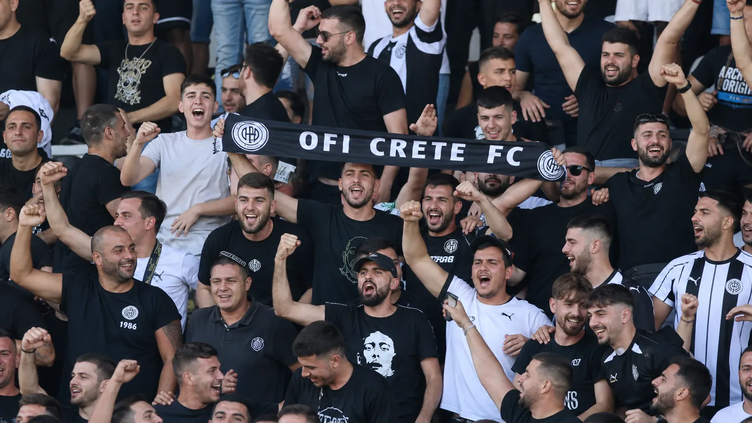 Supporters van OFI Kreta vieren in de tribunes een Europese thuiszege.