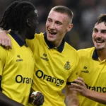 Drie spelers van Union vieren samen tijdens een Europa League-wedstrijd.