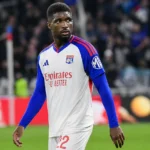 Een Lyon-speler in een wit-blauw tenue tijdens een wedstrijd op een verlicht veld.