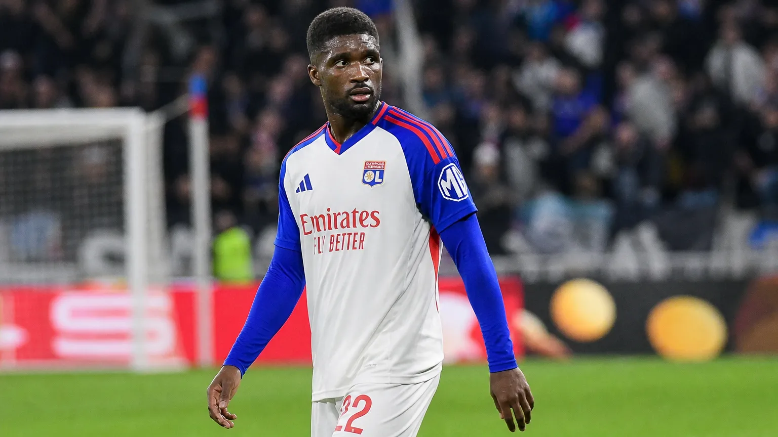 Een Lyon-speler in een wit-blauw tenue tijdens een wedstrijd op een verlicht veld.