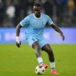 Mouhamed El Bachir Ngom controleert de bal op een verlicht voetbalveld.