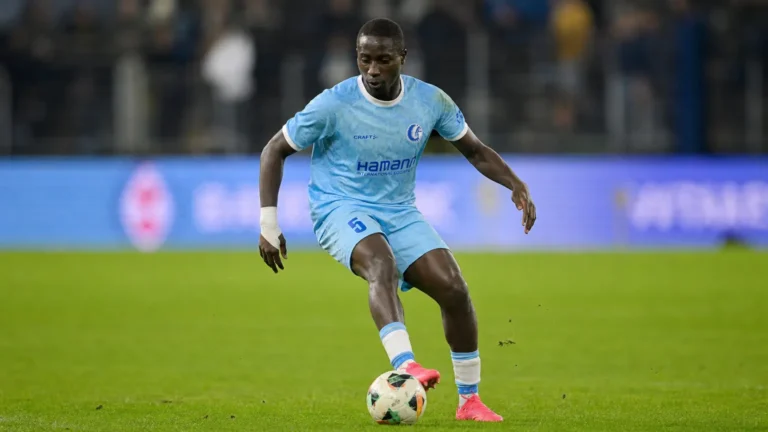 Mouhamed El Bachir Ngom controleert de bal op een verlicht voetbalveld.
