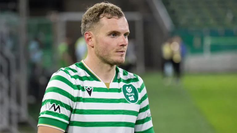 Philippe Rommens in een groen-wit gestreept voetbalshirt aan de rand van het veld.