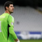 Thibaut Courtois in groen doelmanstenue bij een doel in een stadion.
