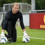 Brian Vandenbussche op het trainingsveld van Tubeke met twee voetballen.