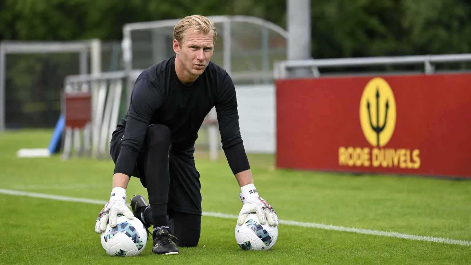 Brian Vandenbussche op het trainingsveld van Tubeke met twee voetballen.