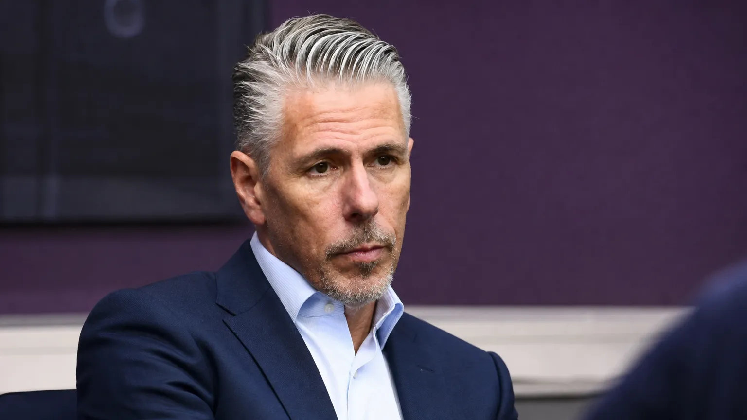 Michael Verschueren in pak tijdens een voetbalinterview.