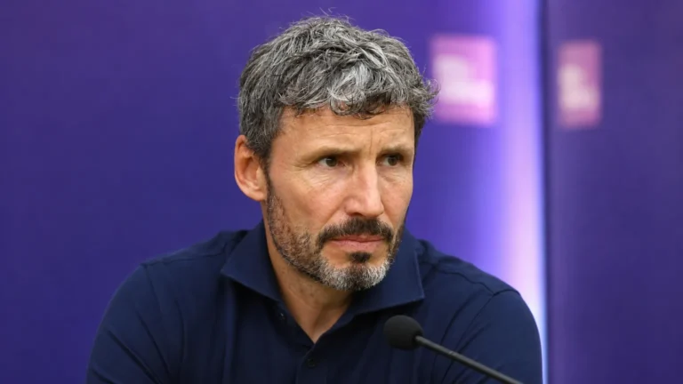 Mark van Bommel tijdens een persconferentie in een donkerblauwe polo.