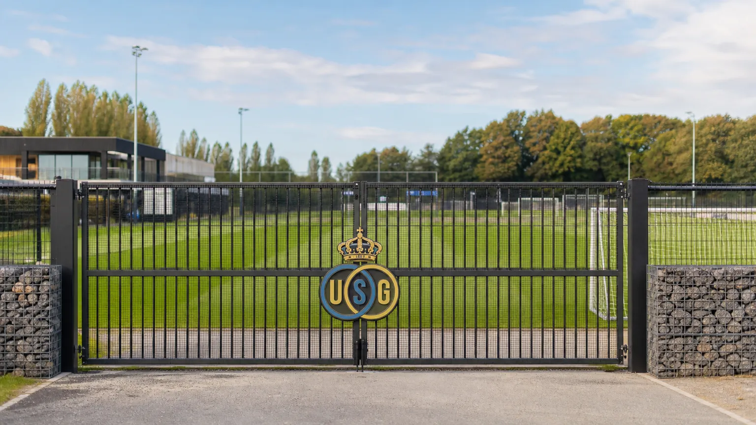 Leeg trainingsveld van Union met het clubembleem aan de toegangspoort.