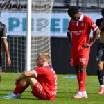 Spelers van KV Kortrijk staan ontgoocheld bij het doel na een wedstrijdmoment.