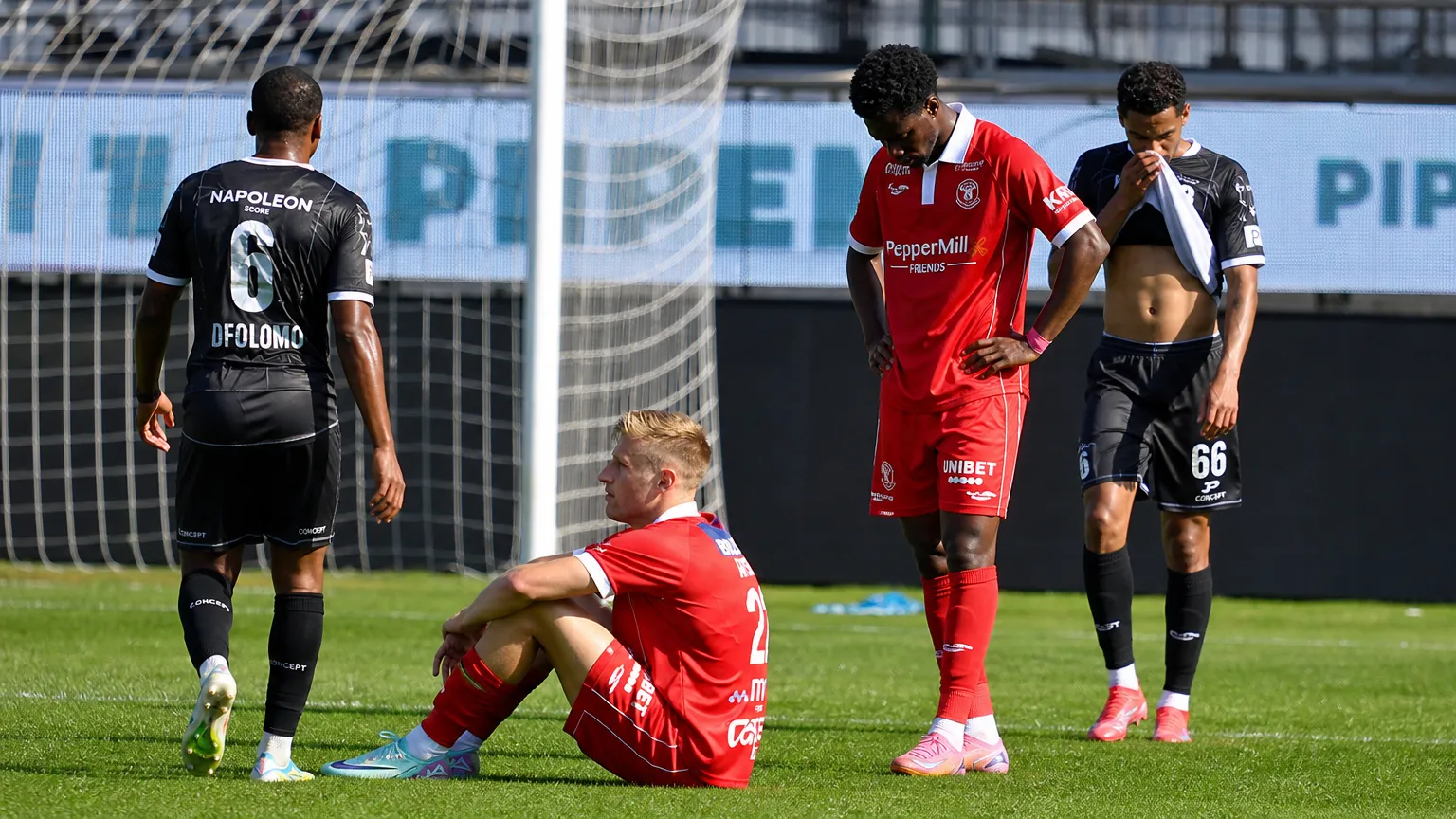 Spelers van KV Kortrijk staan ontgoocheld bij het doel na een wedstrijdmoment.
