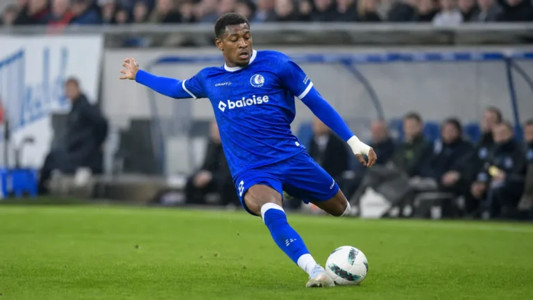 Een KAA Gent-speler in blauw wedstrijdtenue in duel om de bal.
