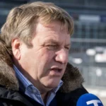 Johan Boskamp spreekt tijdens een voetbalinterview in openlucht.