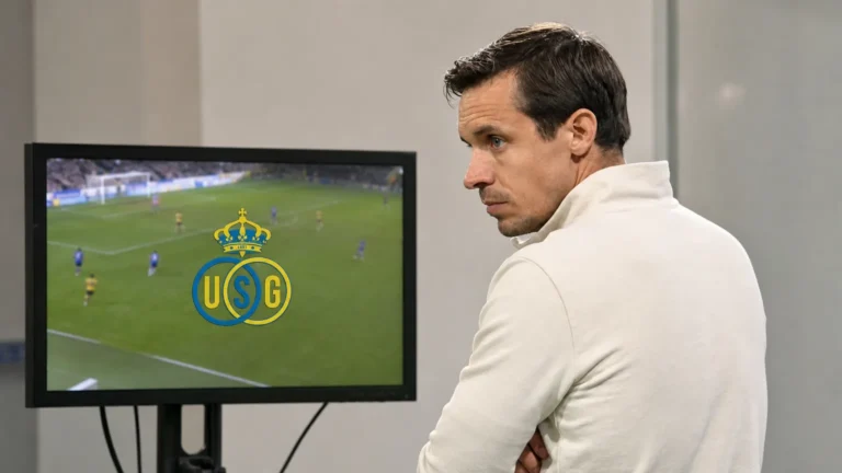 Franky Van der Elst bekijkt beelden op een monitor met het embleem van Union.